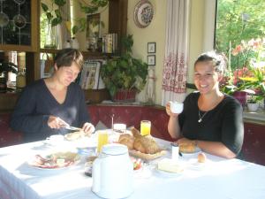 dos mujeres sentadas en una mesa comiendo comida en Gästehaus Wieser, en Haus im Ennstal