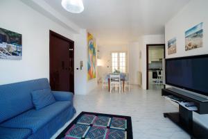 a living room with a blue couch and a flat screen tv at Home Barbera in Castellammare del Golfo