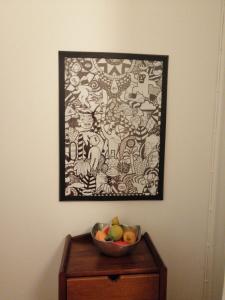 Apartment Junqueiro في بورتو: صحن فاكهة على طاولة مع صورة على الحائط
