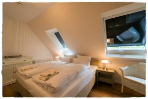 a bedroom with a large white bed with a window at Bauernkate Lilie in Liepe in Rankwitz