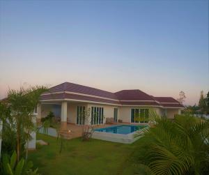 a house with a swimming pool in the yard at Villa de Veluwe @ Hua Hin in Hua Hin