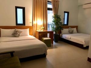 a hotel room with two beds and a window at Guang Cyuan homestay in Magong