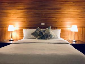 a bedroom with a large white bed with two lamps at Guang Cyuan homestay in Magong +21 photos