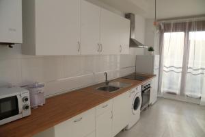 Apartamentos Turísticos Puente Romano P2 2-A في سلامنكا: مطبخ أبيض مع حوض وميكروويف
