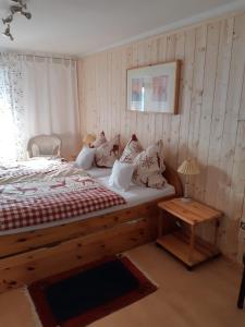Schlafzimmer mit einem Holzbett und einem Tisch in der Unterkunft Haus Mauken - Appartments mit Panoramablick in Murau