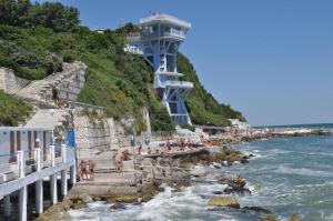 a group of people on a beach with a lighthouse at A un Passetto dal Conero in Ancona