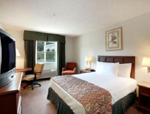 a hotel room with a bed and a flat screen tv at Baymont by Wyndham Yreka in Yreka