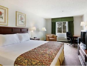 a hotel room with two beds and a television at Baymont by Wyndham Yreka in Yreka