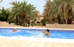 duas pessoas a nadar numa piscina em Open Sky Villa em Denia