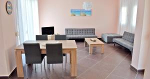 a living room with a table and chairs and a couch at Villa Nina in Skala Rachoniou