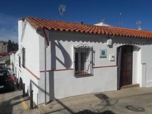 ein kleines weißes Gebäude mit einem vergitterten Fenster in der Unterkunft Casa Torrubia in Aracena