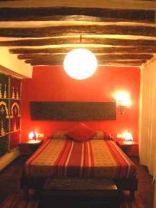 a bedroom with a bed with a red wall at Casa Maza in Asque