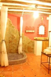 a bathroom with a shower with curtains on the wall at Casa Maza in Asque