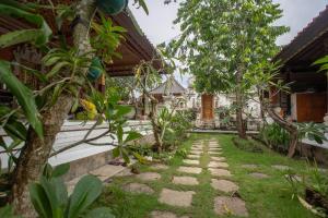 a garden outside a house with a walkway at Nushe Hostel & Room in Nusa Penida +8 photos