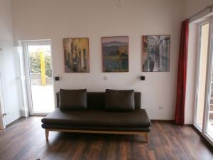 ヴァルデックにあるLuxurious Apartment in Waldeck with Saunaの壁画のある部屋の黒いソファ