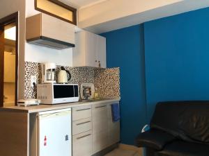 cocina con microondas y pared azul en Office-Studio Theoxaris, en Tesalónica