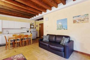 a living room with a leather couch and a kitchen at Città Antica Charming Flat in Verona