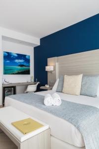 a bedroom with a large bed with a blue wall at Royal Palm Resort & Spa - Adults Only in Playa Jandia
