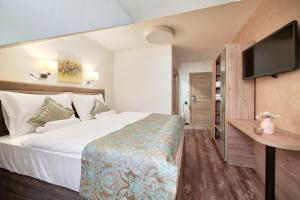 ein Hotelzimmer mit einem Bett und einem Flachbild-TV in der Unterkunft Hotel Tiffany in Kassel