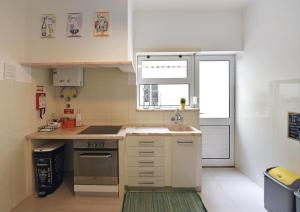 a small kitchen with a sink and a stove at D Wan Guest House in Peniche