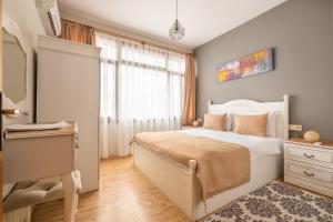 Schlafzimmer mit einem Bett, einem Schreibtisch und einem Fenster in der Unterkunft Old Town Deluxe Flats in Antalya