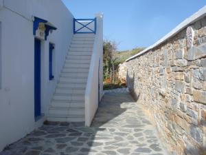 a stairway leading up to a building with a stone wall at Blue Horizon Ios in Ios Chora