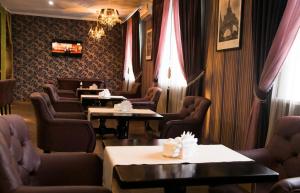 a waiting room with tables and chairs and curtains at Гостиница ШАНЫРАК in Qyzylorda