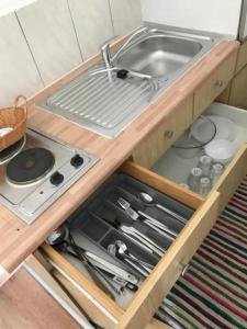 a kitchen with a sink and a drawer with utensils at Arbeiterwohnungen Graz Hauptbahnhof in Graz