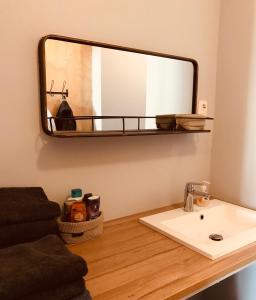 baño con lavabo y espejo en la pared en Stay and Sea, en Harlingen