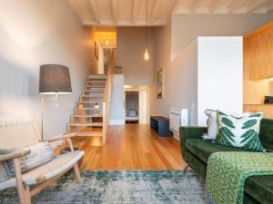 sala de estar con sofá verde y escalera en Domum 3 en Oporto