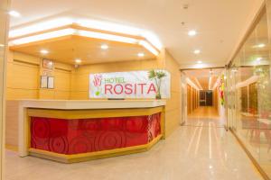 un vestíbulo de hotel con un cartel de rosas en la pared en Hotel Rosita en Lucena