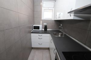 una pequeña cocina con fregadero y microondas en DIFFERENTFLATS Grd, en Salou