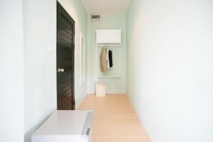 a hallway with a black door and a white toilet at Baan Ploy In in Chiang Mai +37 photos