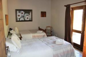 1 Schlafzimmer mit 2 Betten und einem Fenster in der Unterkunft Ribboksfontein Guest Farm in De Rust