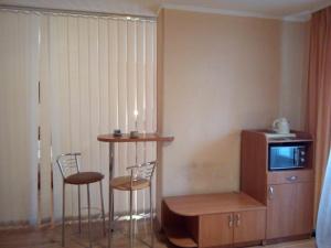 ein Zimmer mit zwei Stühlen, einem Tisch und einem Fernseher in der Unterkunft Comfort Hotel in Kiew