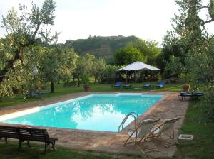 a swimming pool with chairs and a table and umbrella at La Chiusetta in Orvieto