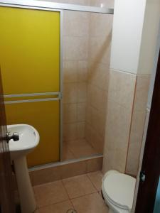 a bathroom with a shower with a toilet and a sink at Hotel Nuevo Amanecer Malabrigo in Puerto Chicama