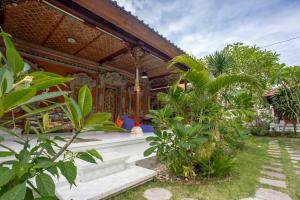 a house with a garden in front of it at Nushe Hostel & Room in Nusa Penida
