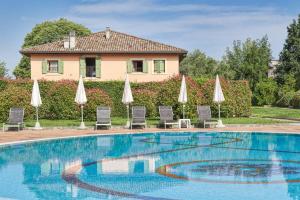 a swimming pool with umbrellas and chairs and a house at Active Hotel Paradiso in Peschiera del Garda
