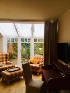 a living room with a couch and a tv at Gästehaus Schloss Bothmer in Schwarmstedt