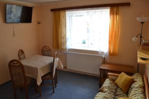 sala de estar con mesa, sofá y ventana en Apartmán Anežka Albrechtice, en Albrechtice v Jizerských horách 5 fotos más