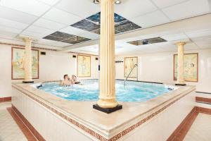 a soaking pool with two people in it at Carlton President in Utrecht