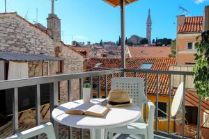 un sombrero y un libro sobre una mesa en un balcón en Apartment Orkić, en Rovinj