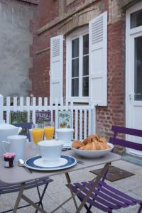 einen Tisch mit einer Schüssel Croissants und Orangensaft in der Unterkunft Villa Arthur in Deauville