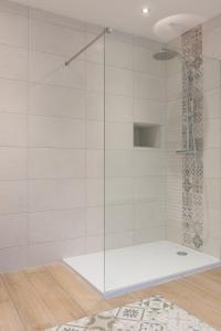 um chuveiro com uma porta de vidro na casa de banho em Villa Arthur em Deauville