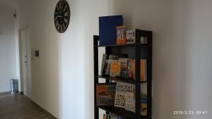 une étagère avec des livres et une horloge sur un mur dans l'établissement GARBATELLA'S in ROME, à Rome