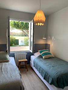 a bedroom with a bed and a window at La Maison de l’Ocean - plage à 75 mètres in Saint-Martin-de-Ré
