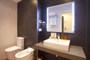 y baño con lavabo, aseo y espejo. en Hotel Pompaelo Plaza del Ayuntamiento & Spa, en Pamplona