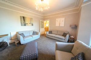 a living room with two couches and a chandelier at Harcourt Hotel in Ilfracombe