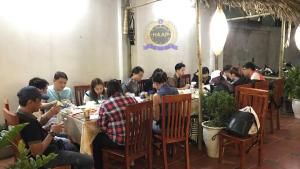 a group of people sitting at tables in a restaurant at HAAP Transit Hotel in Noi Bai